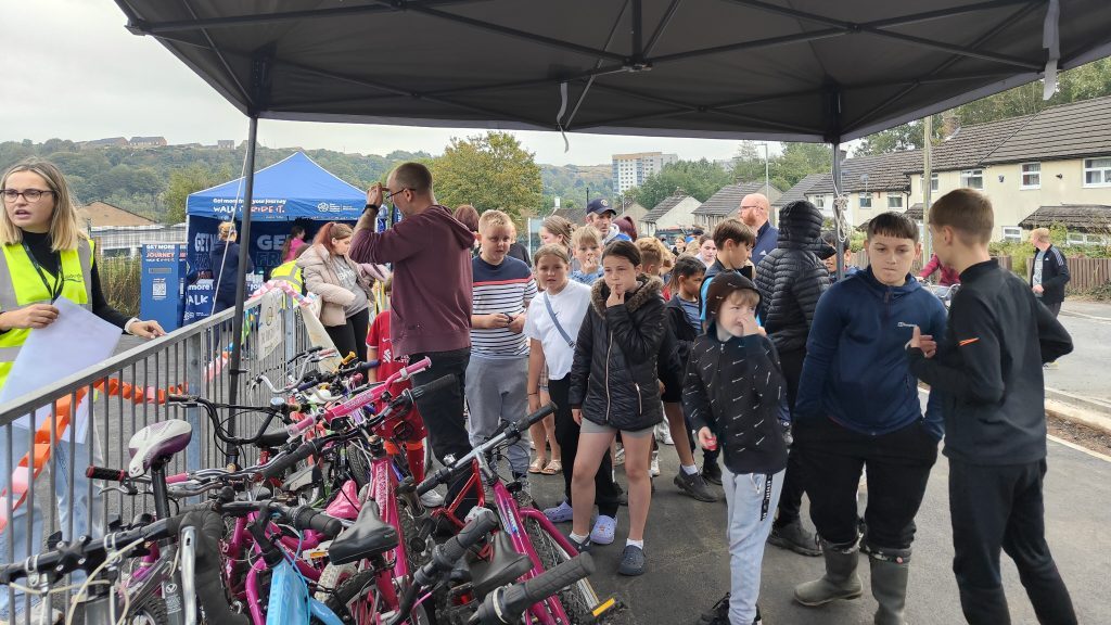 Children queuing for bikes at Mixinden Party in the Parks. 