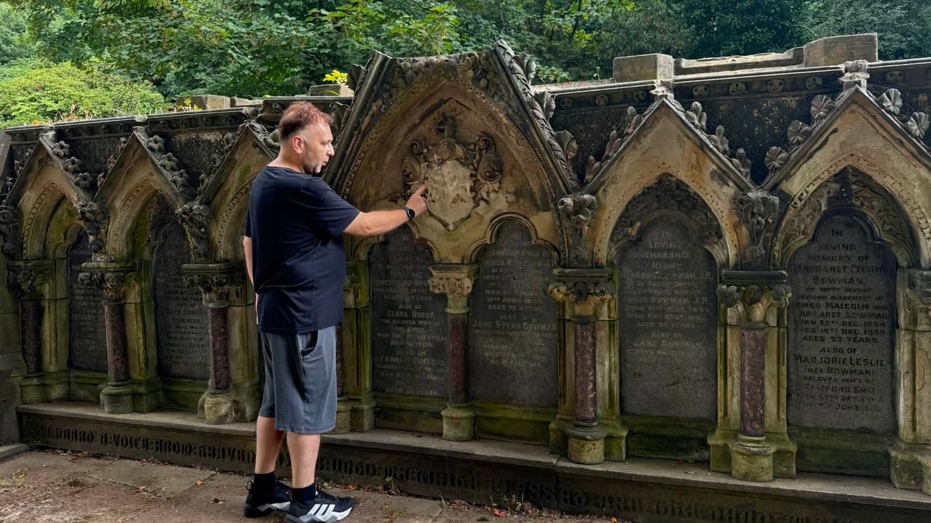 Krzysztof stands in front of a restored tomb, showcasing the careful conservation work.